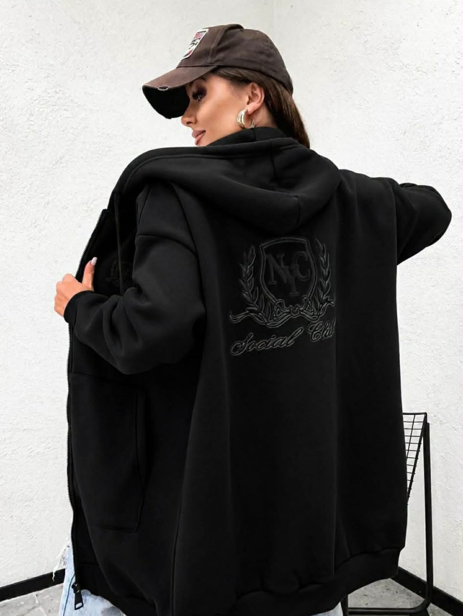 Damska czarna bluza oversize z kapturem i dużym haftem Social Club na plecach. Gruba rozpinana bluza z bawełny w nowoczesnym, casualowym stylu.