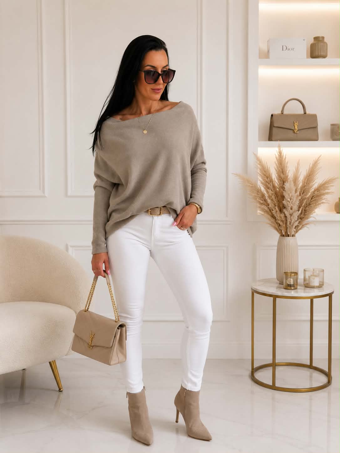 Elegancki damski sweter oversize z dodatkiem kaszmiru w kolorze fango, zestawiony z białymi spodniami i beżową torebką – stylizacja łącząca wygodę i ponadczasową elegancję.