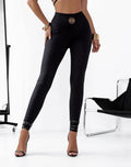 Czarne legginsy Basari Zip Push Up z wysokim stanem i złotym logo, prezentowane w eleganckiej stylizacji damskiej.