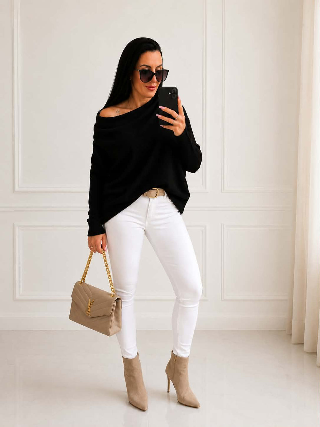 Elegancki damski sweter oversize z dodatkiem kaszmiru w czarnym kolorze, zestawiony z białymi spodniami i beżową torebką – ponadczasowa stylizacja na co dzień, do pracy i na wieczorne wyjścia.