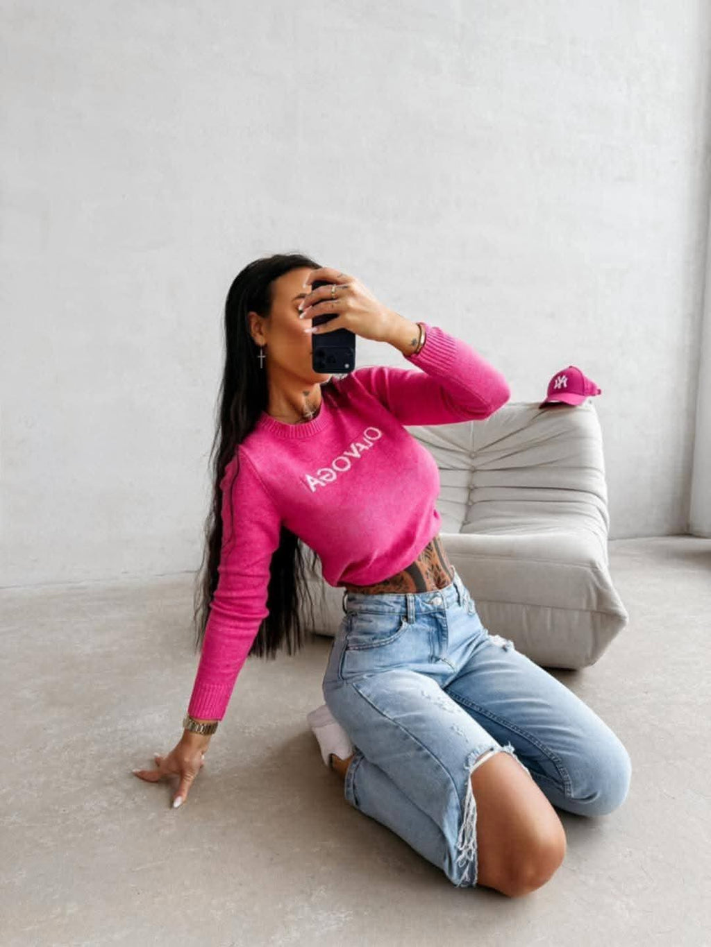 Dopasowany sweter damski OLAVOGA w kolorze fuksji, długi rękaw, styl casual, modelka w jeansach, modny look streetwear premium