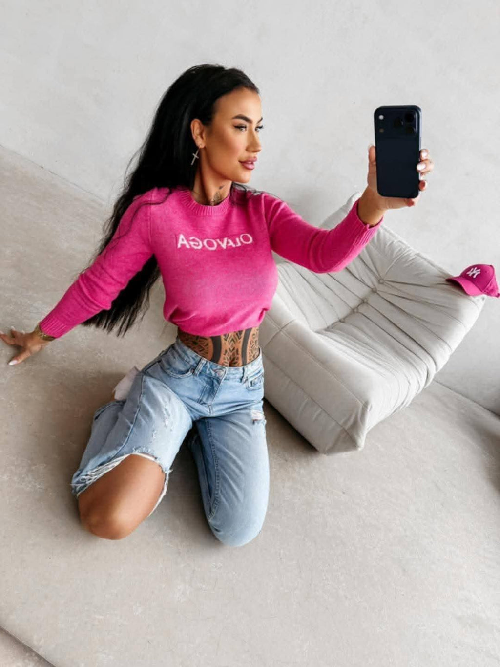 Dopasowany sweter damski OLAVOGA w kolorze fuksji, długi rękaw, styl casual, modelka w jeansach, nowoczesny look streetwear premium