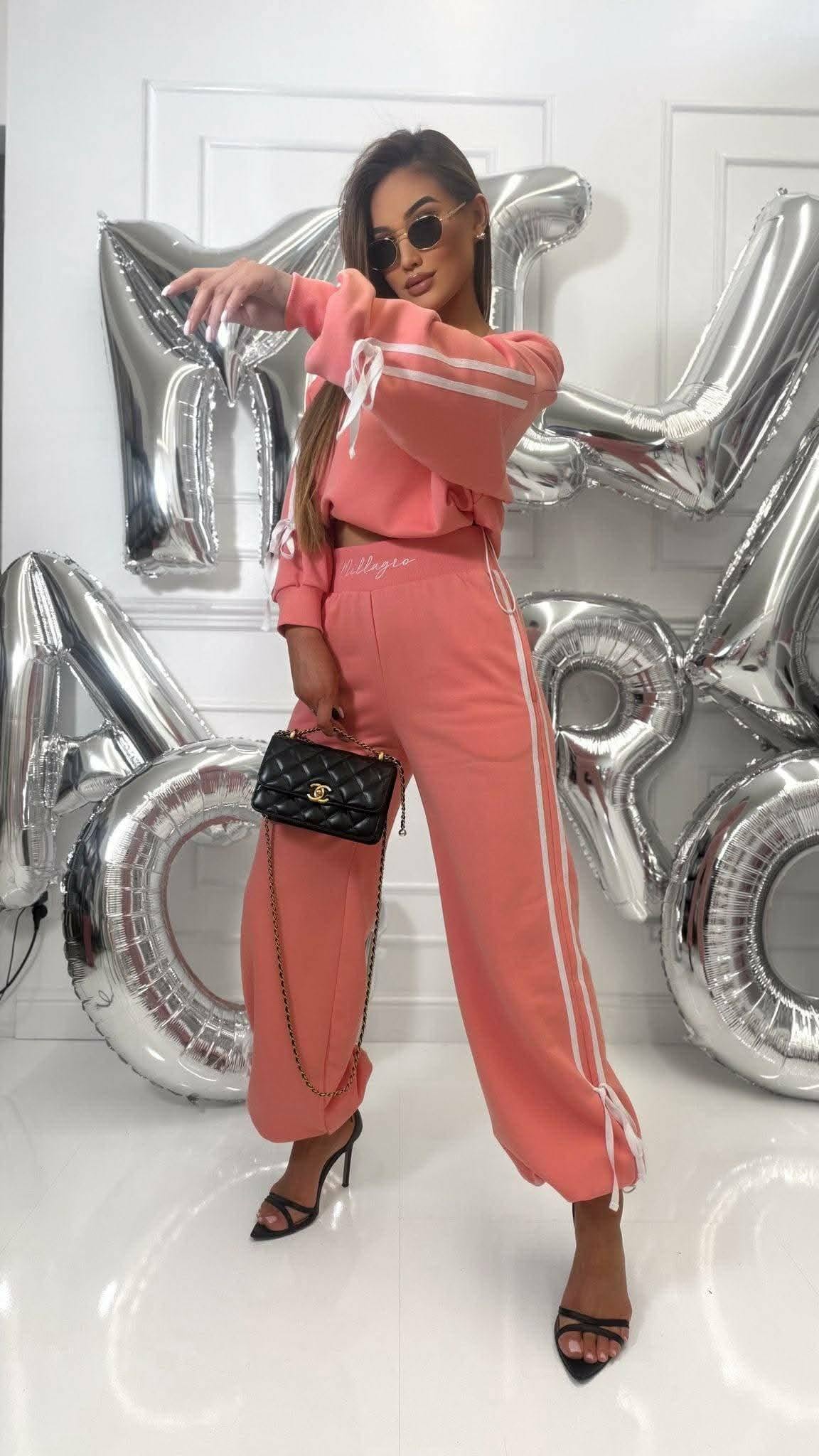 Stylowy dres damski oversize w kolorze koralowym Millagro, komplet bluza i spodnie z lampasami, modna stylizacja casual z torebką i szpilkami