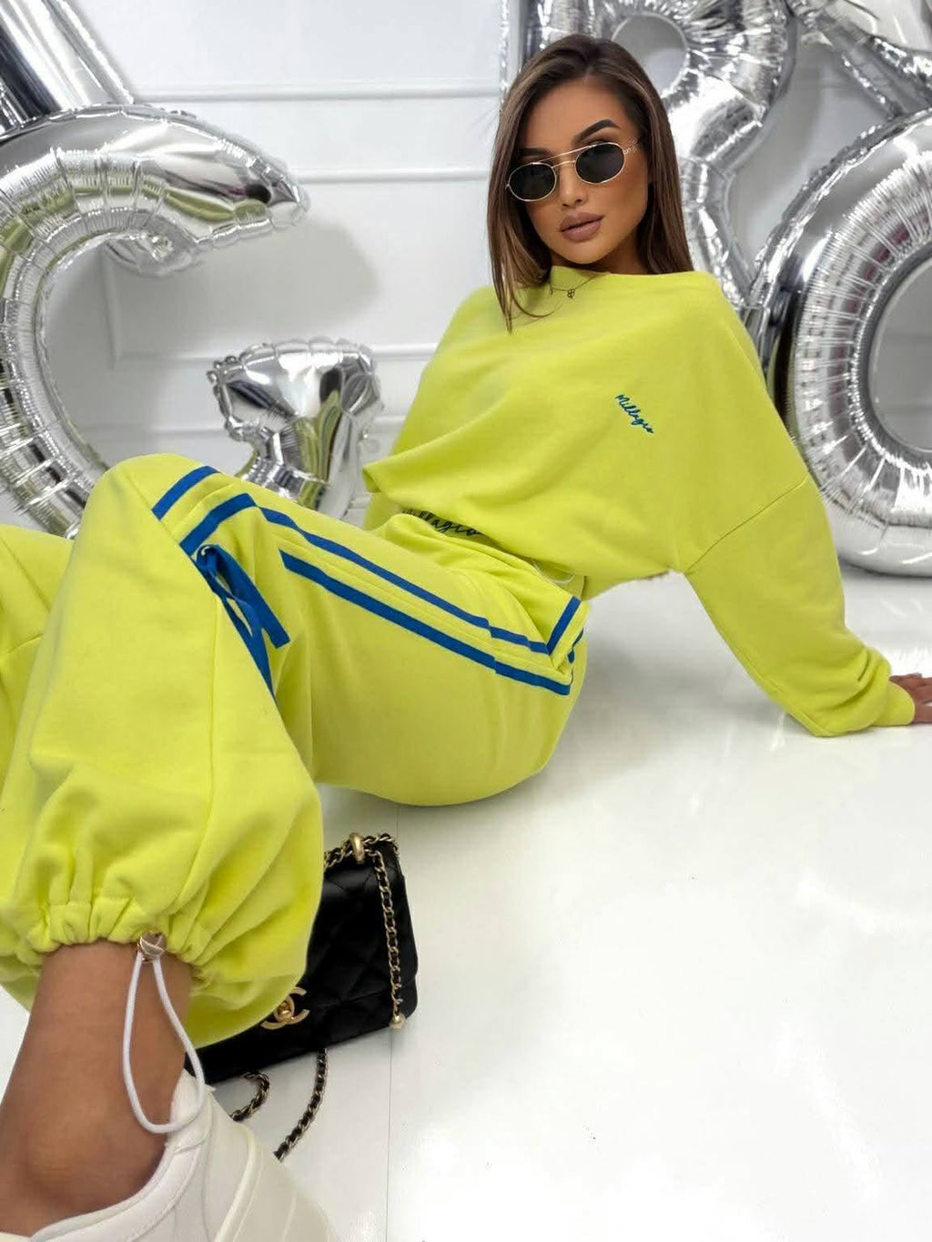 Modny dres damski Millagro w kolorze limonkowym, oversize komplet sportowy z niebieskimi lampasami, casualowy streetwear z elegancką torebką i nowoczesnym stylem