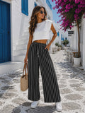 Damskie spodnie wide leg w czarne paski z wysokim stanem i szerokimi nogawkami w letniej stylizacji.